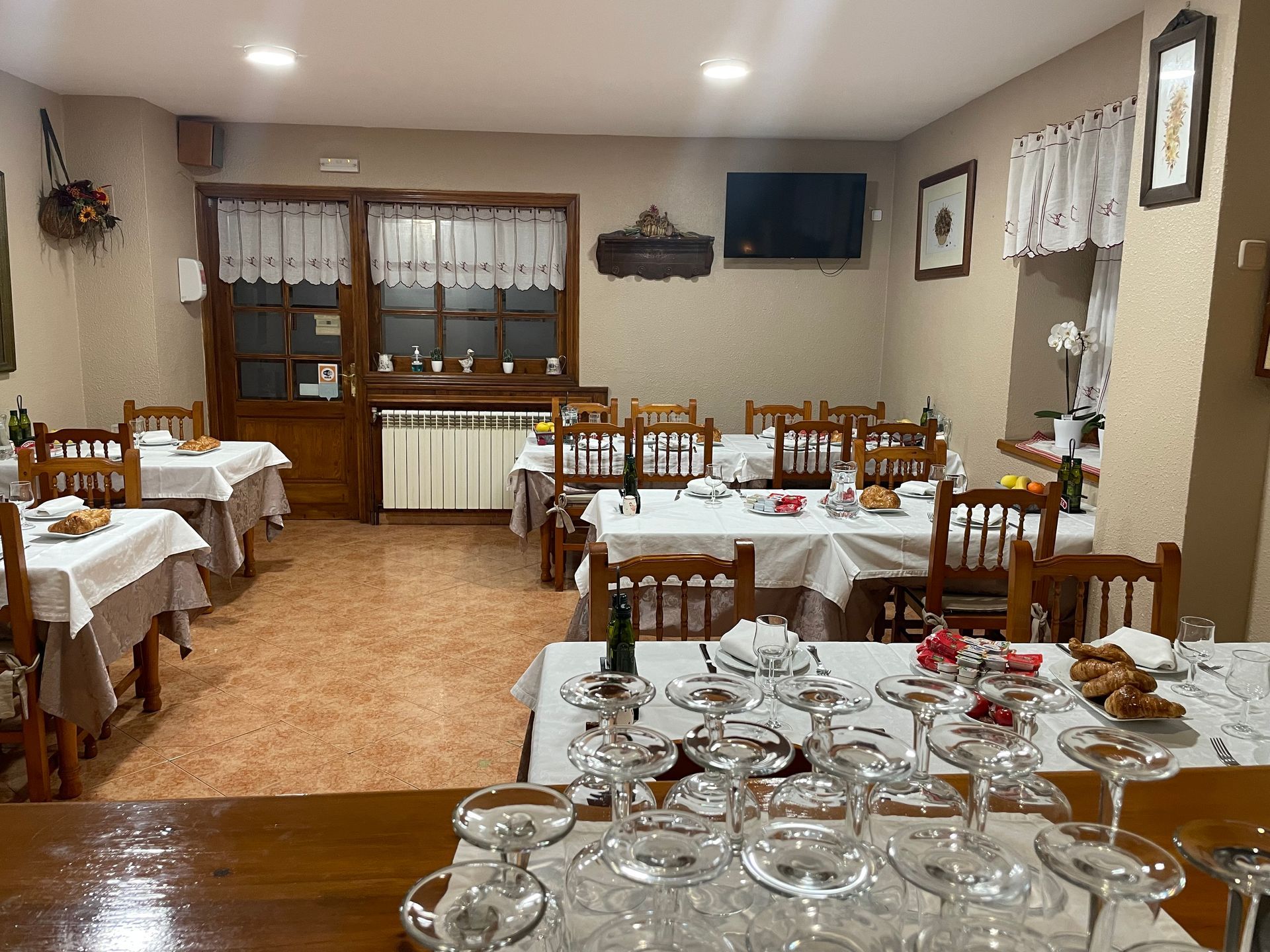 Un restaurante con mesas y sillas y vasos en la mesa.