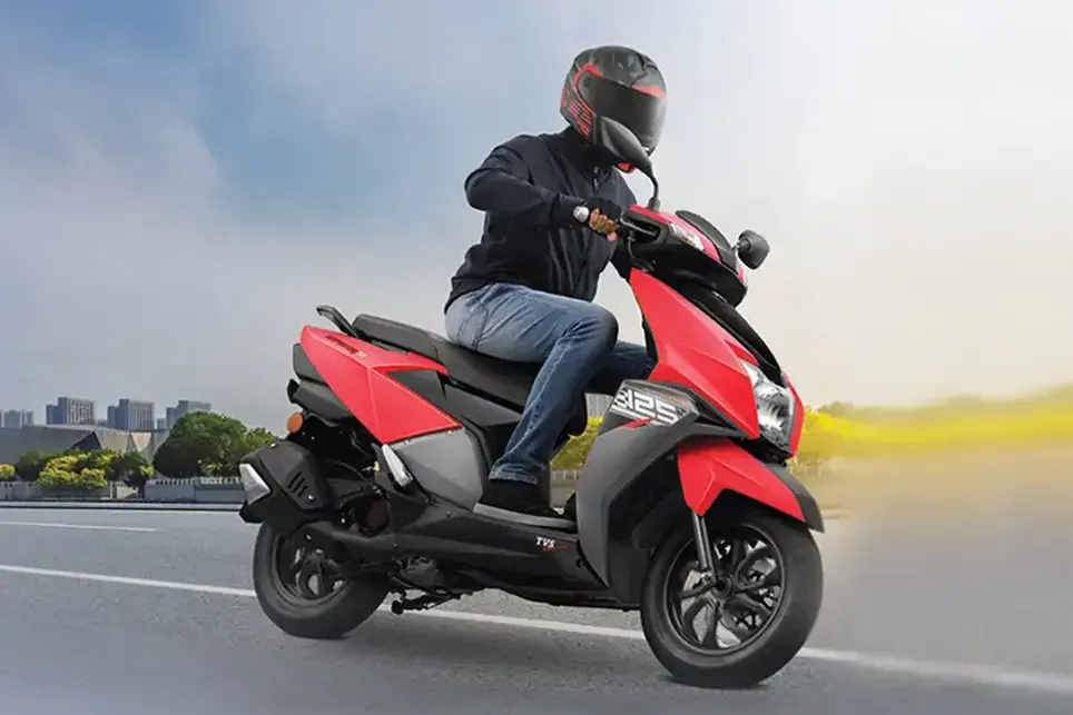 Un motorista en una moto roja circula a gran velocidad por una carretera, con una estela amarilla borrosa a su paso.