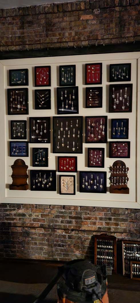 A collection of framed artifacts displayed in a wall niche against a brick wall.