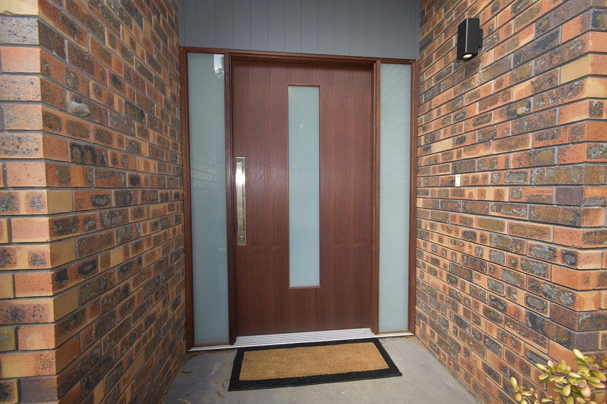A brick wall with a wooden door and a mat