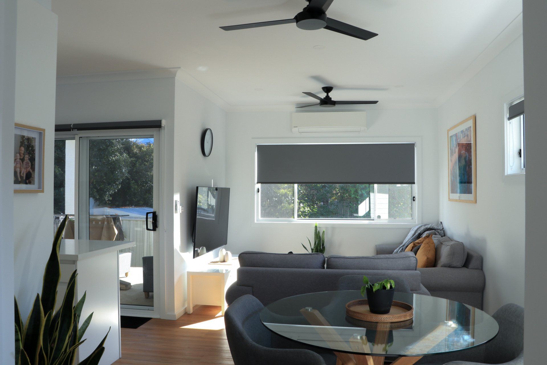 A living room with a table and a ceiling fan