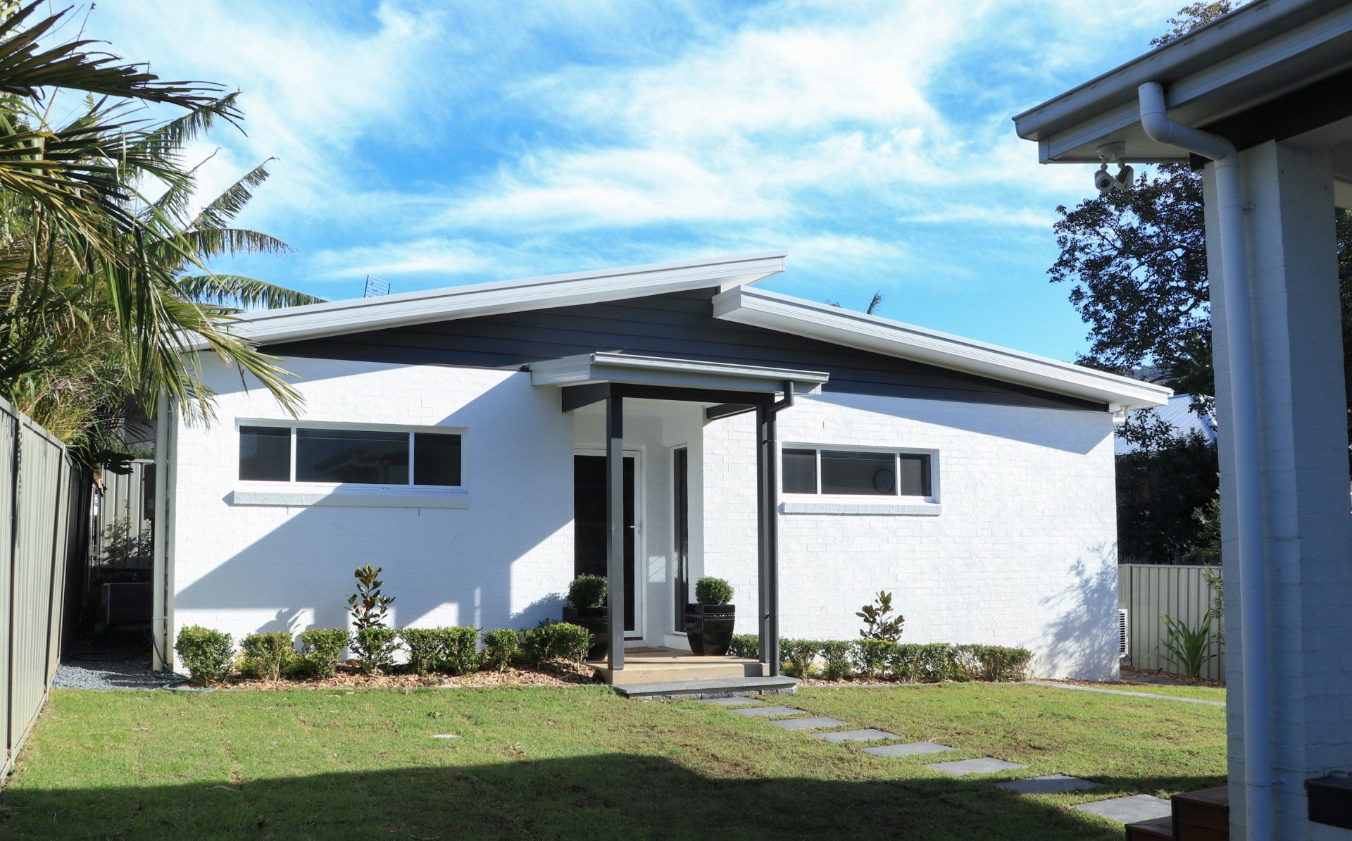 A white house with a black roof and a porch