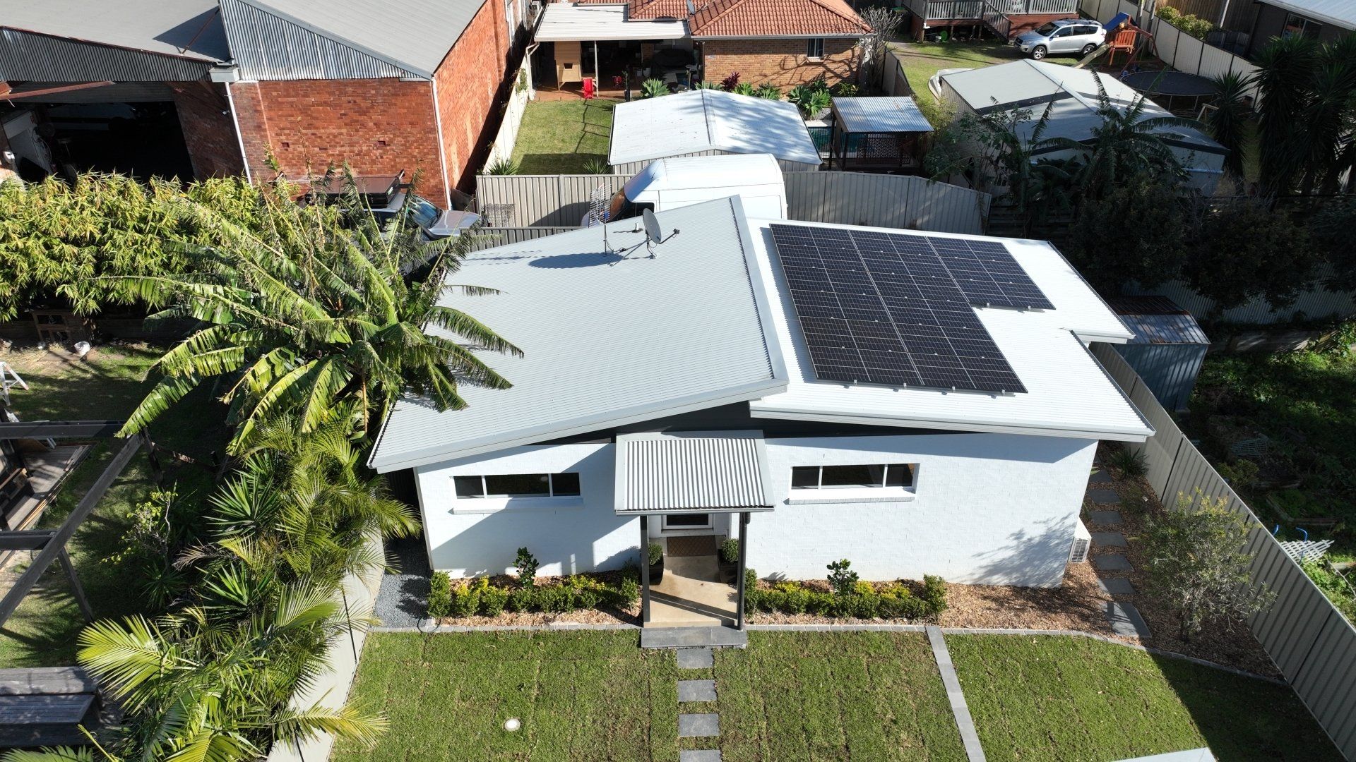 An aerial view of a house with solar panels on the roof.