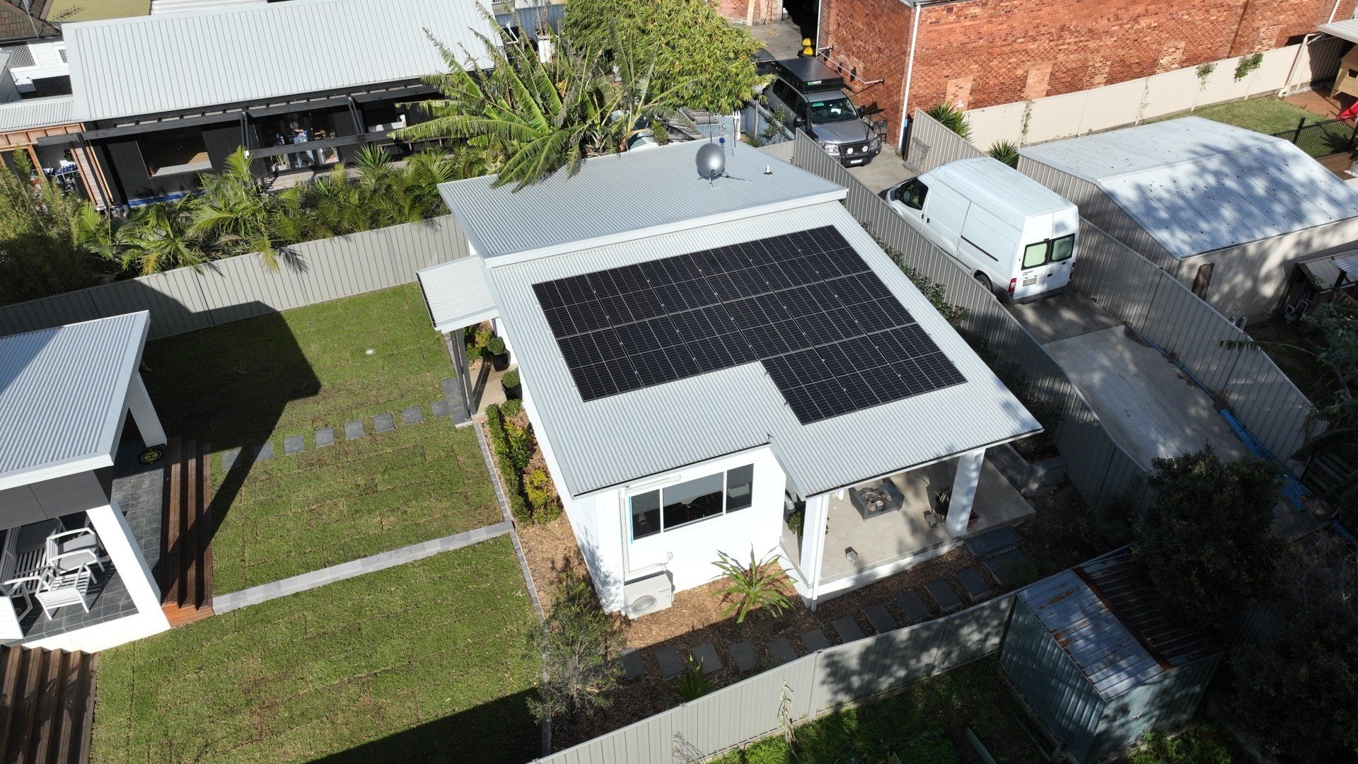 An aerial view of a house with solar panels on the roof.
