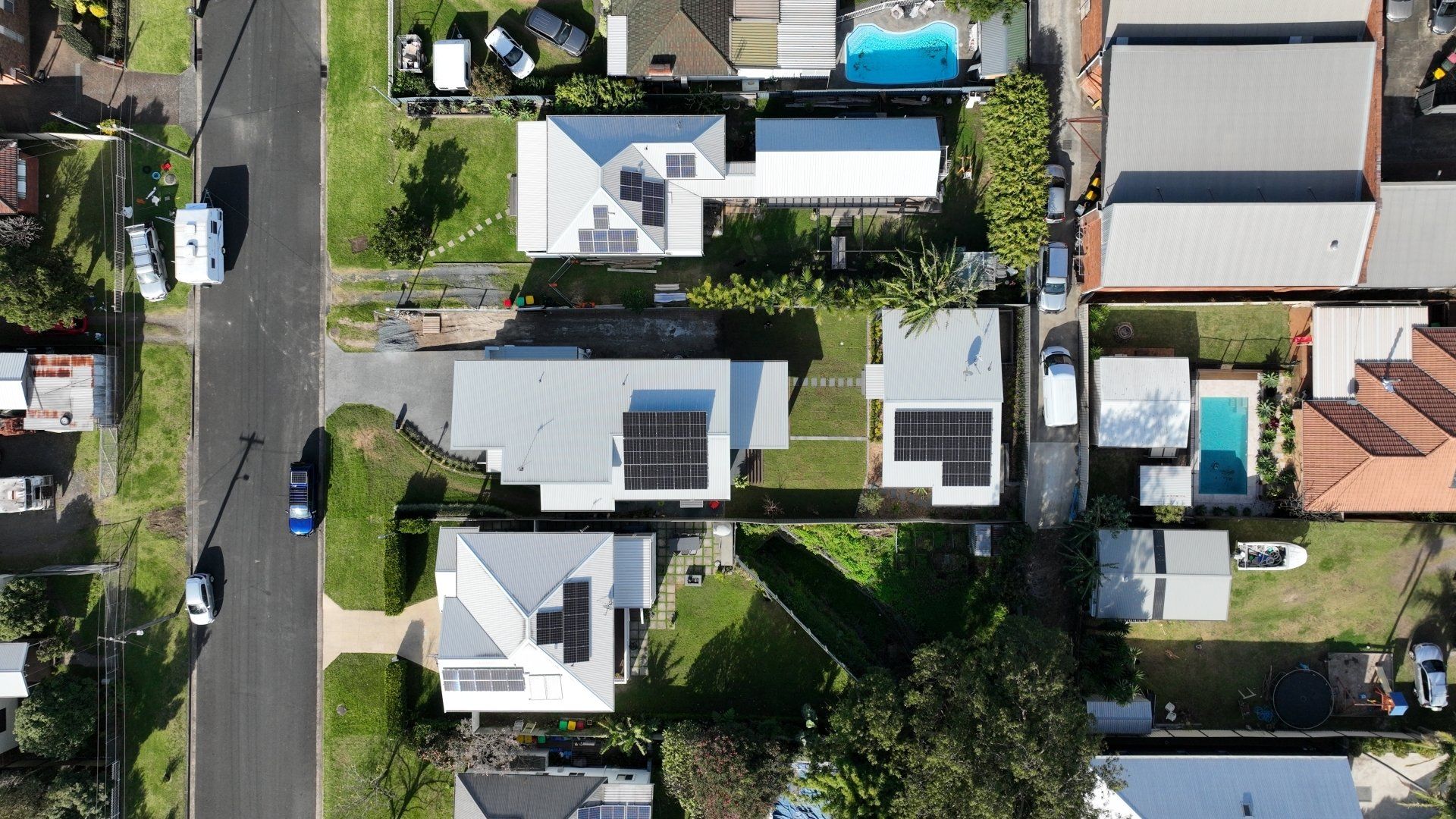 An aerial view of a residential area with houses and a pool