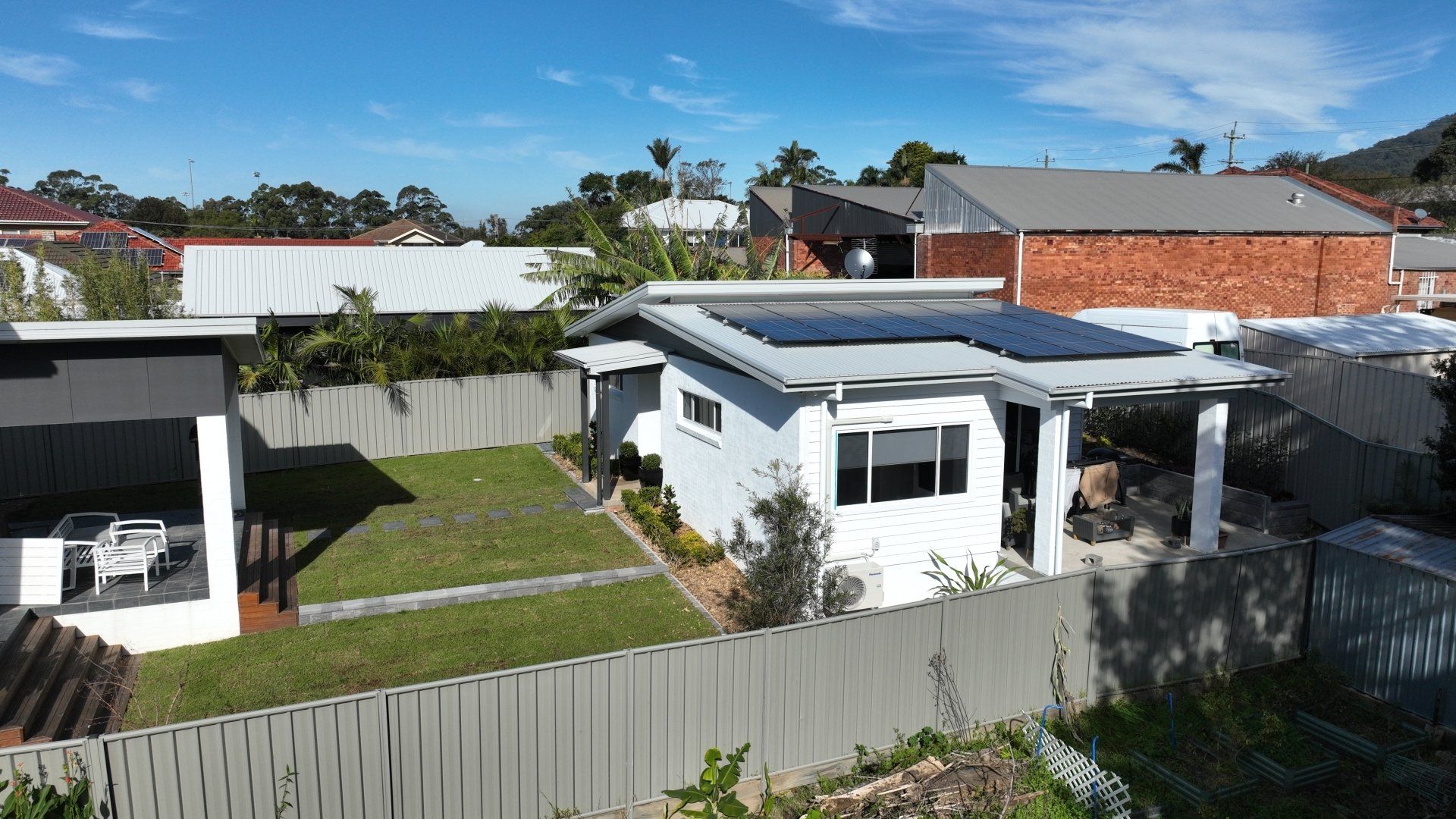 An aerial view of a house with solar panels on the roof