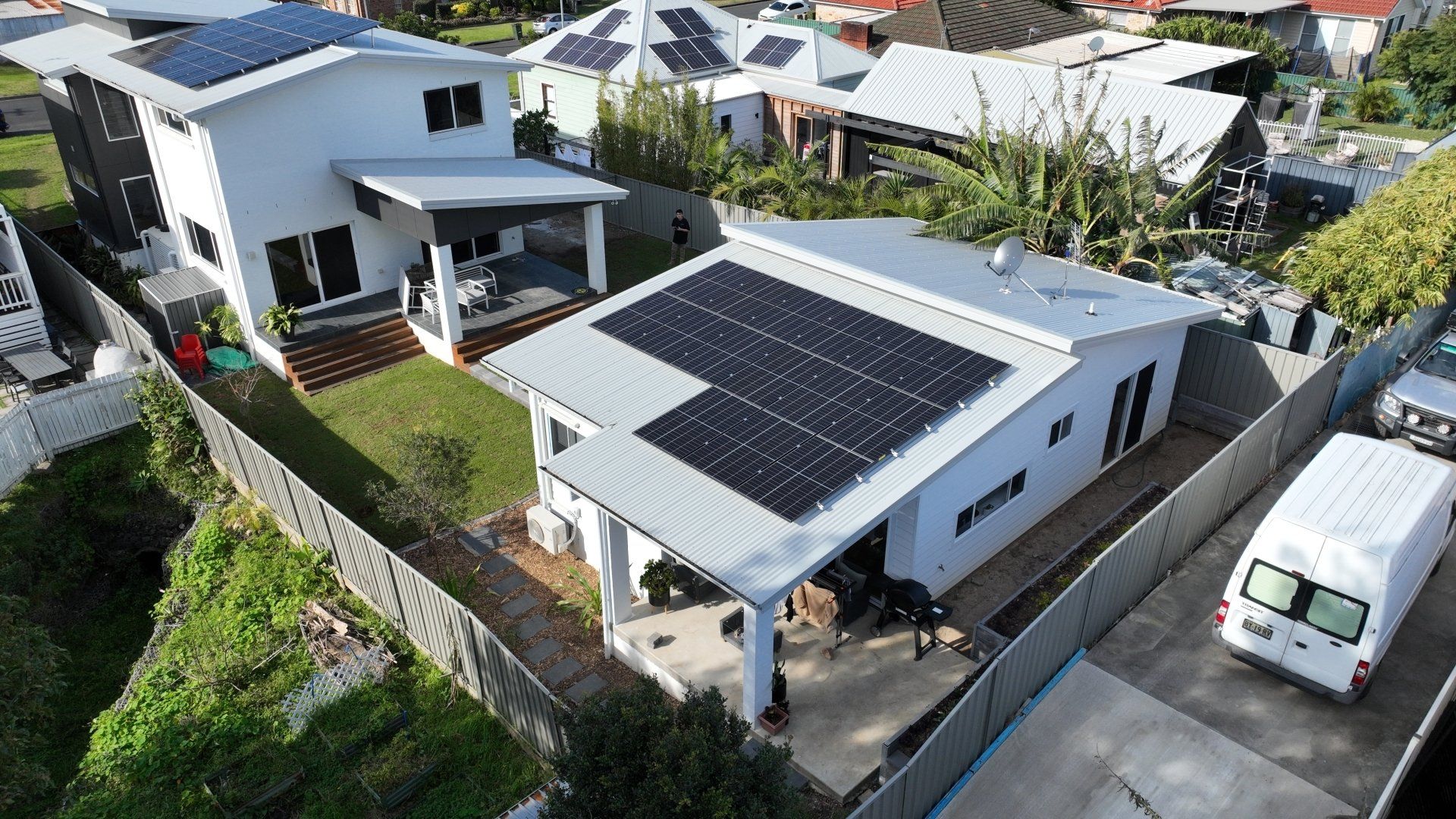 An aerial view of a house with solar panels on the roof