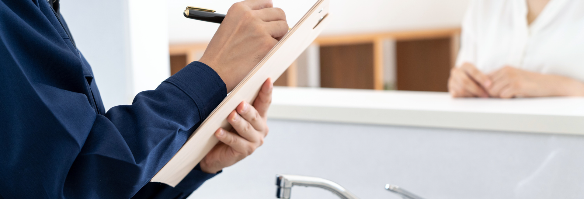 A man is holding a clipboard and writing on it.