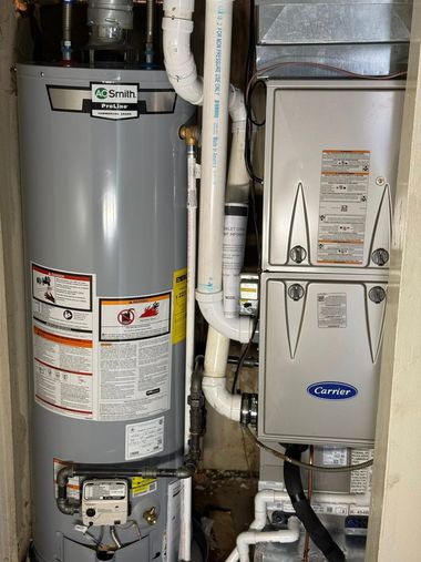 Water heater and furnace in a utility closet with pipes and ductwork