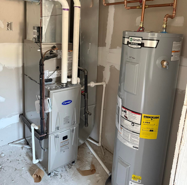 Basement utility area with furnace and water heater beside exposed pipes and copper plumbing.