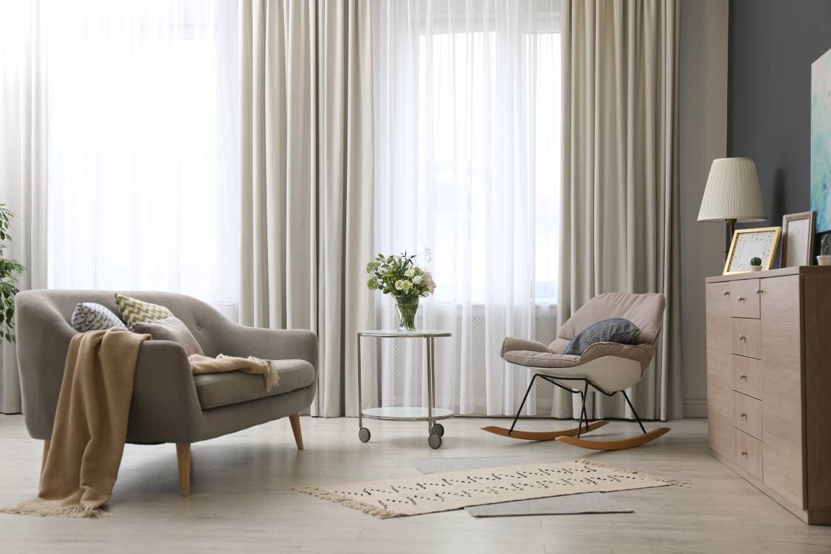 Custom drapery hanging on living room windows in a modern home
