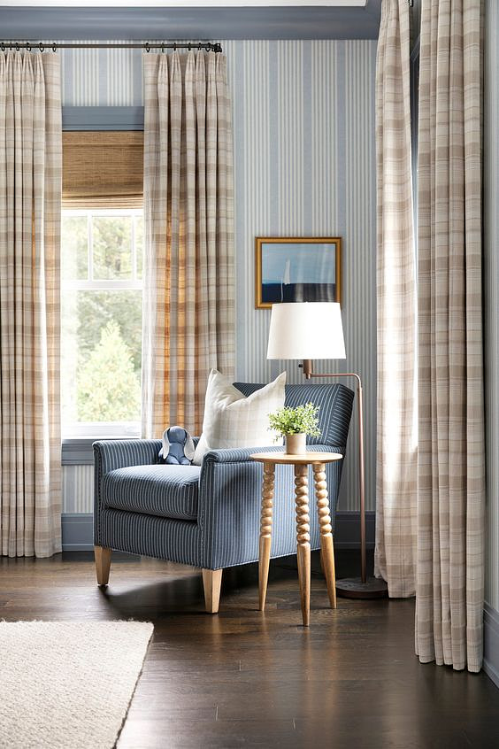 Hunter Douglas Provenance® Woven Wood Shades and patterned custom drapery blocking light in a study.