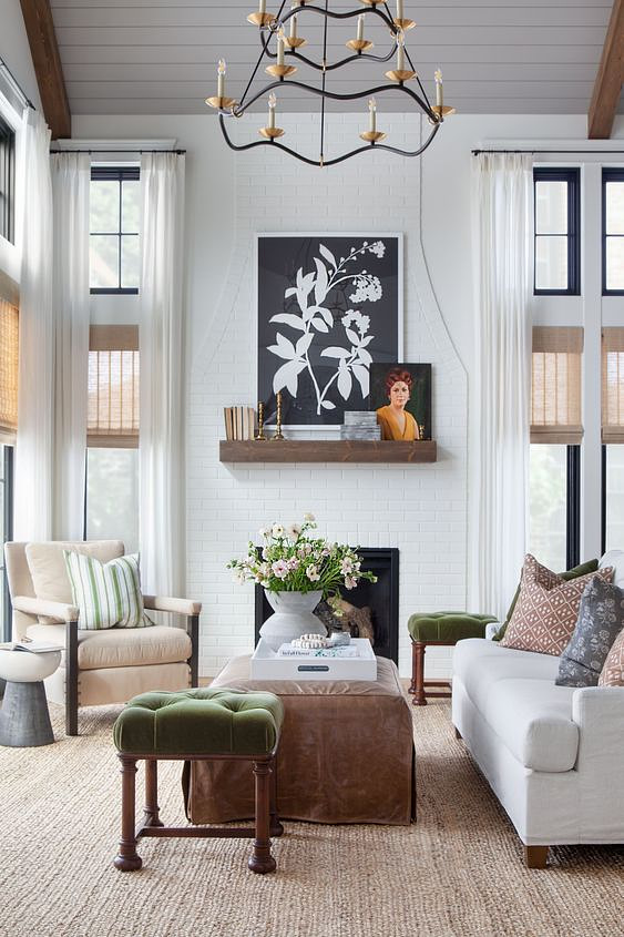 Hunter Douglas Provenance® Woven Wood shades and white custom drapery hanging on multiple living room windows.