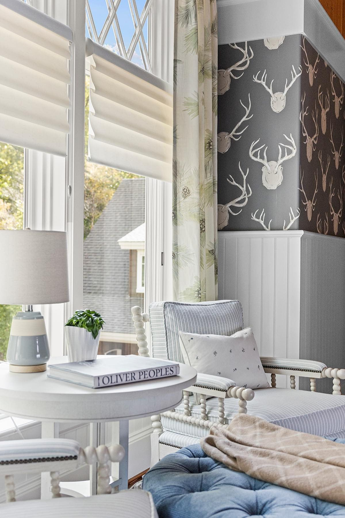 Modern sunroom with white Vignette® Roman Shades and patterned custom drapes.
