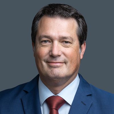 A man in a suit and tie is smiling for the camera.