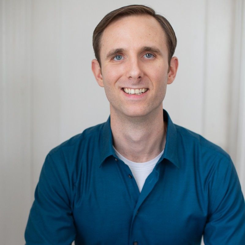 A man in a blue shirt is smiling for the camera