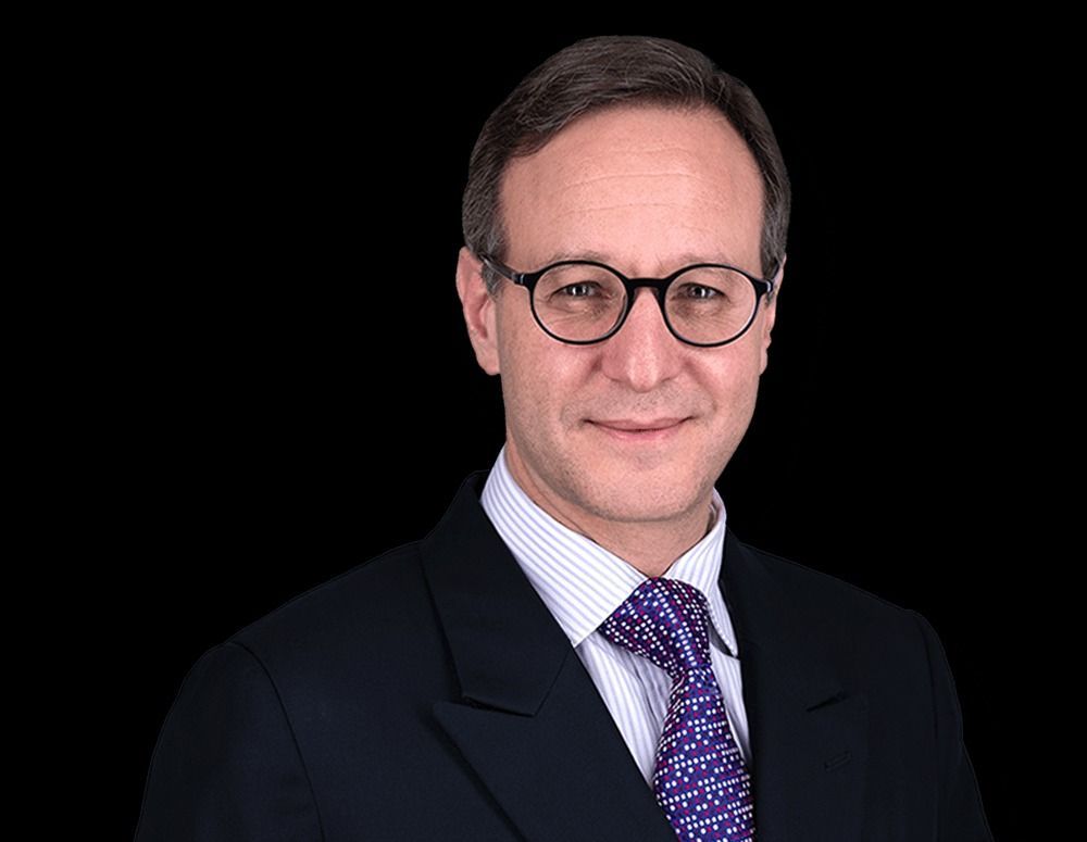 A man in a suit and tie is wearing glasses.