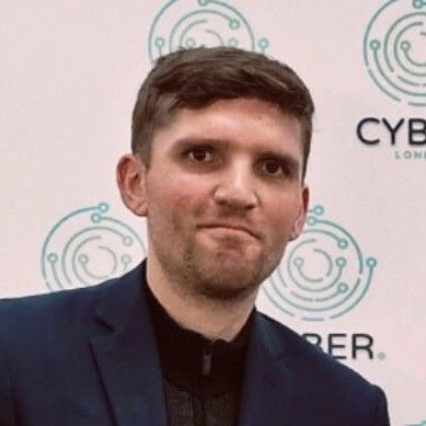 A man in a suit is standing in front of a wall with circles on it.