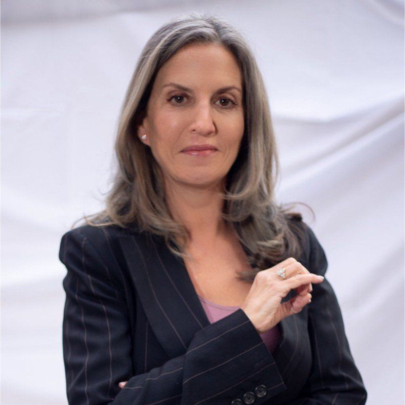 A woman in a black suit with a ring on her finger