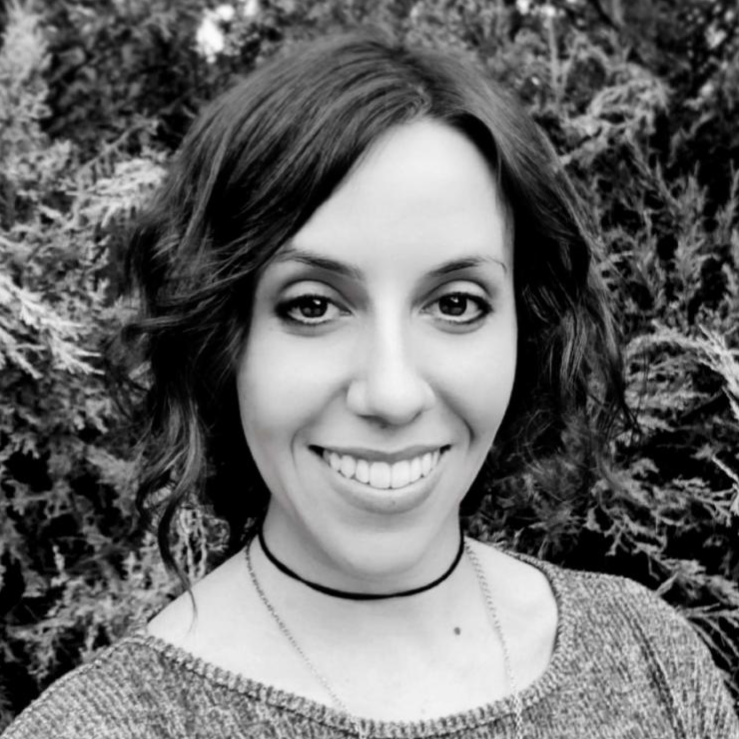 A woman wearing a choker is smiling in a black and white photo.