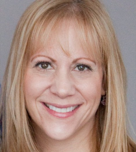 A woman with blonde hair is smiling for the camera