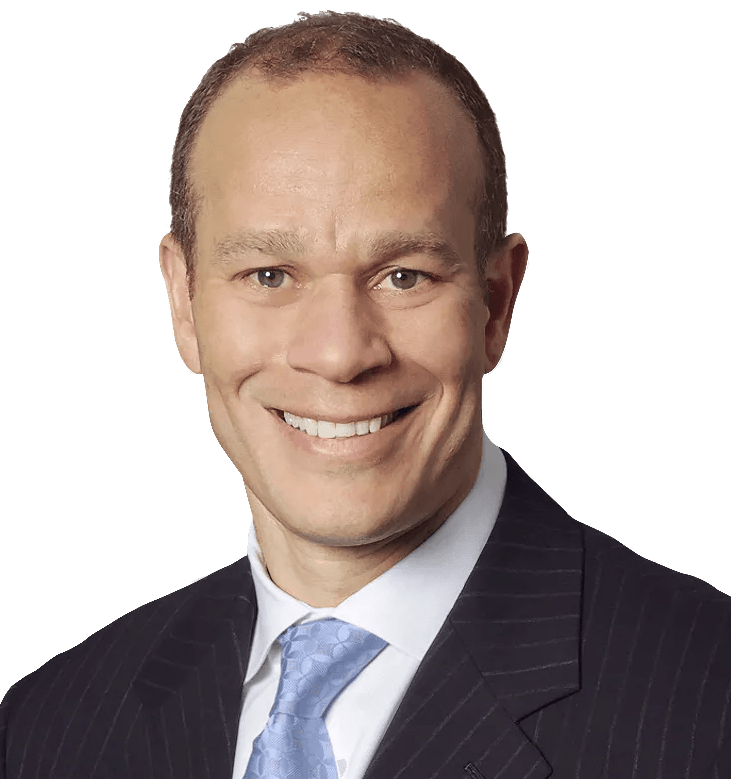 A man in a suit and tie is smiling for the camera