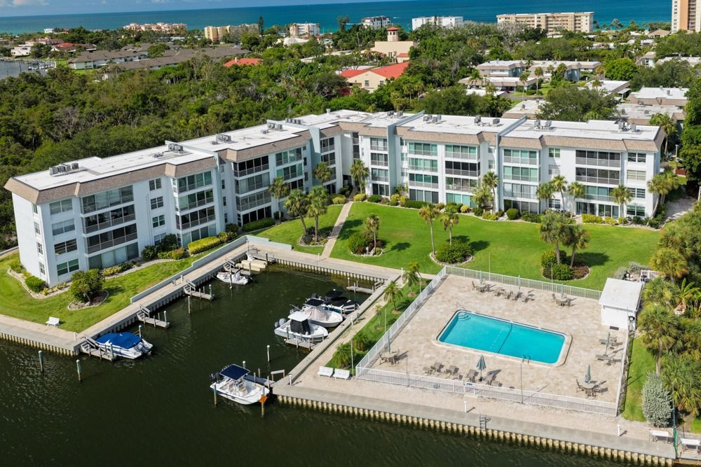 Aerial photograph of waterfront residences, docks, and a swimming pool