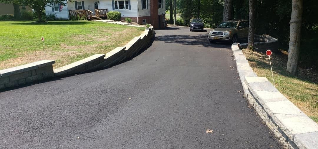 A car is parked on the side of a road next to a house.