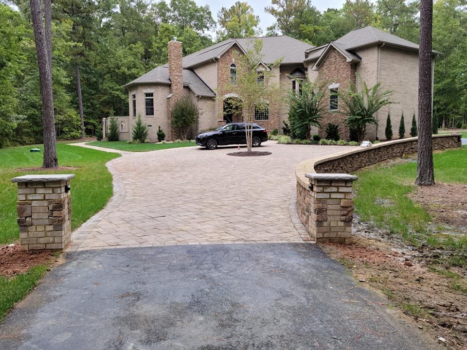 A black car is parked in front of a large house