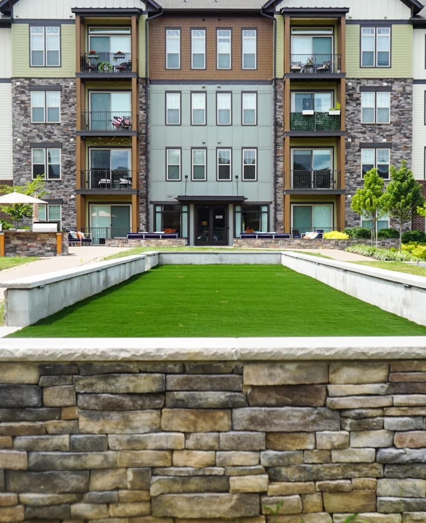 A large apartment building with a large lawn in front of it