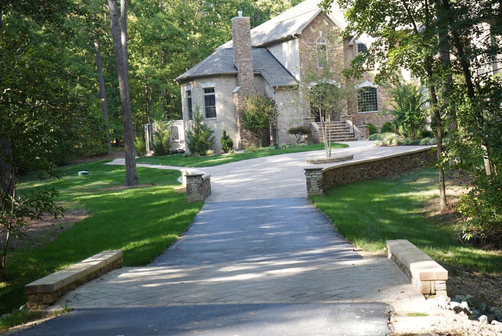 A driveway leading to a large house surrounded by trees