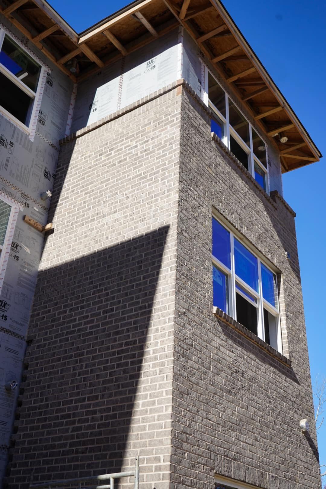 A brick building under construction with a blue sky in the background