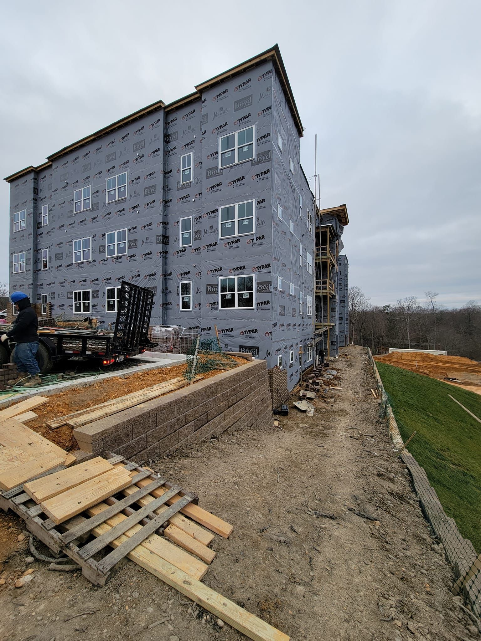 A large building is being built next to a baseball field.