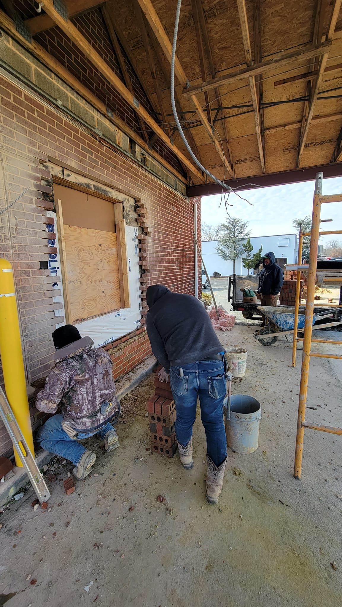 A couple of men are working on a building.
