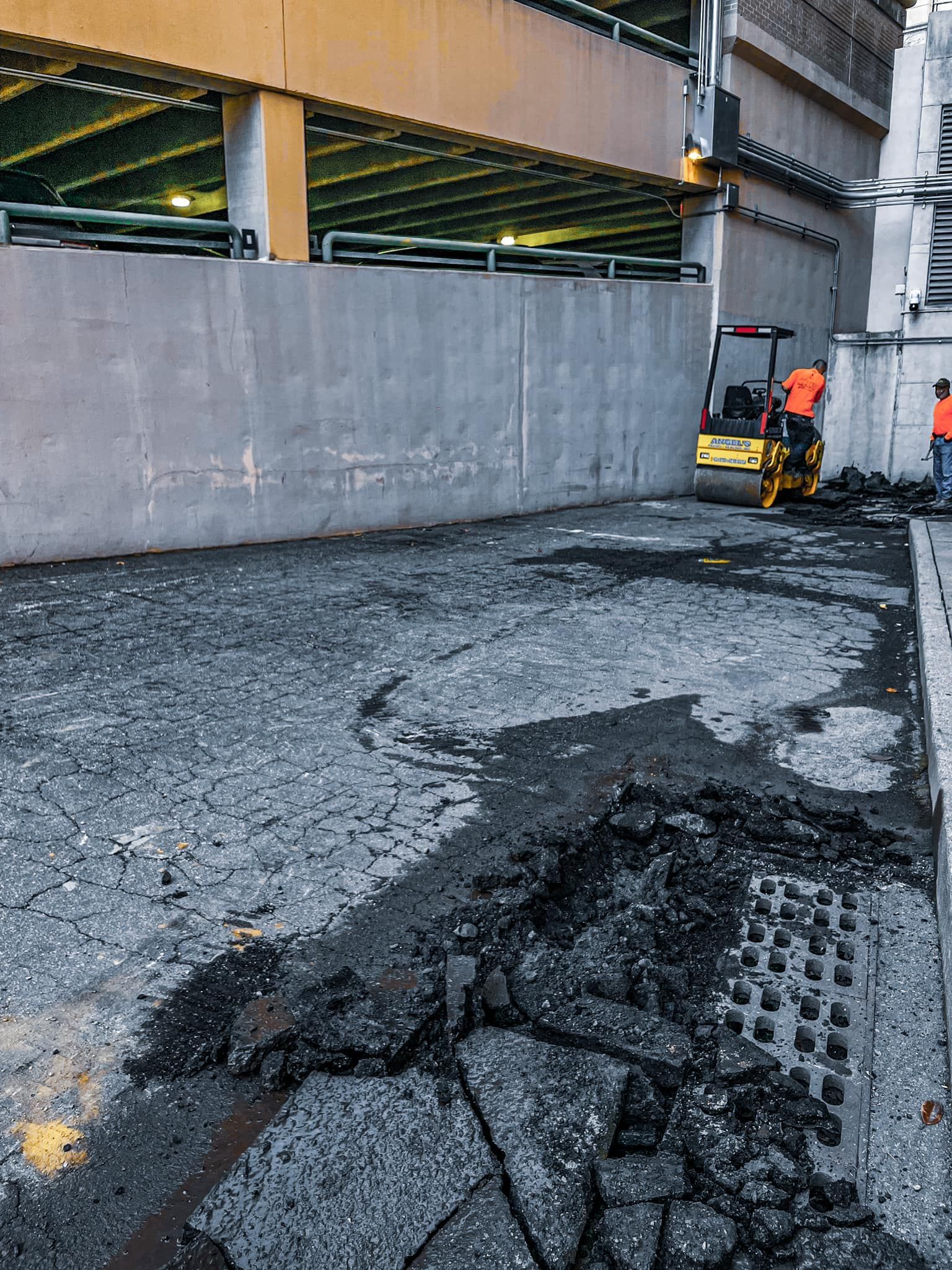 A group of construction workers are working on a parking garage.