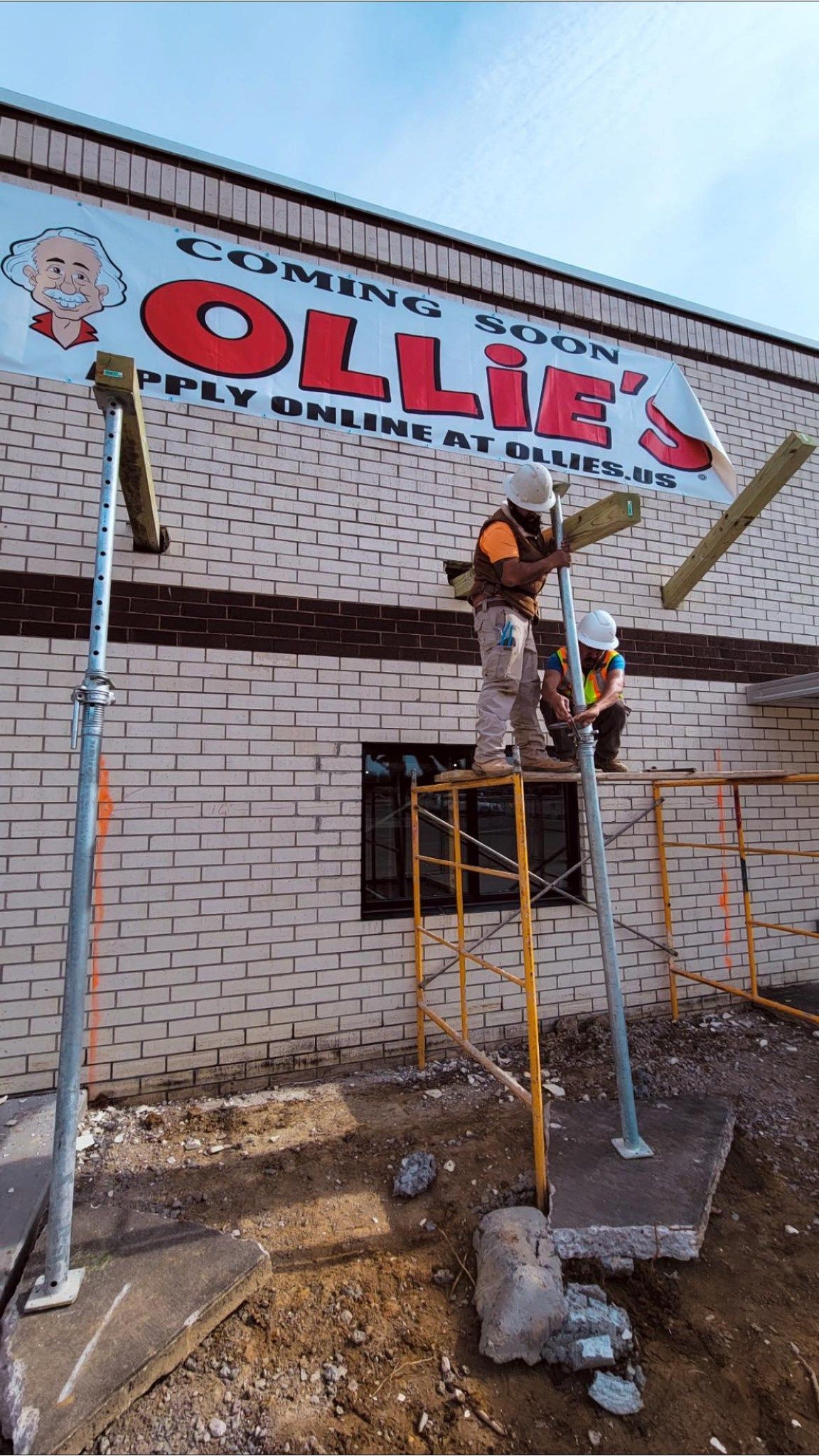 A man is painting a sign on the side of a building.