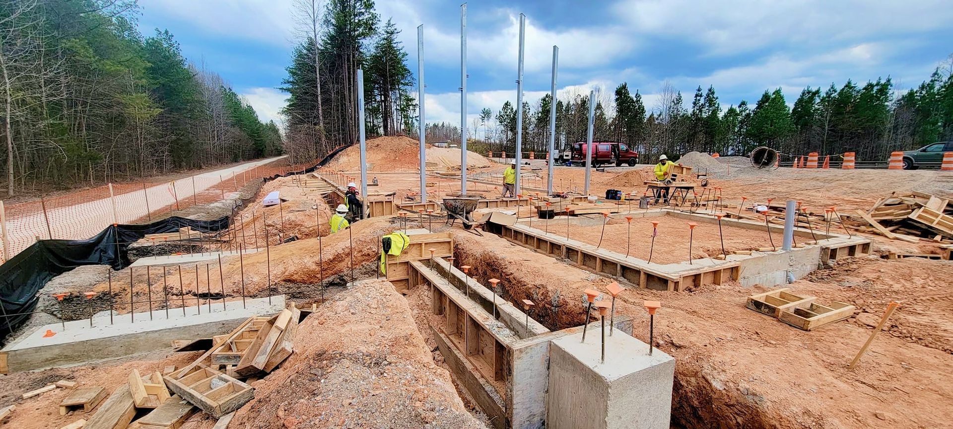 A construction site with a lot of dirt and trees in the background.