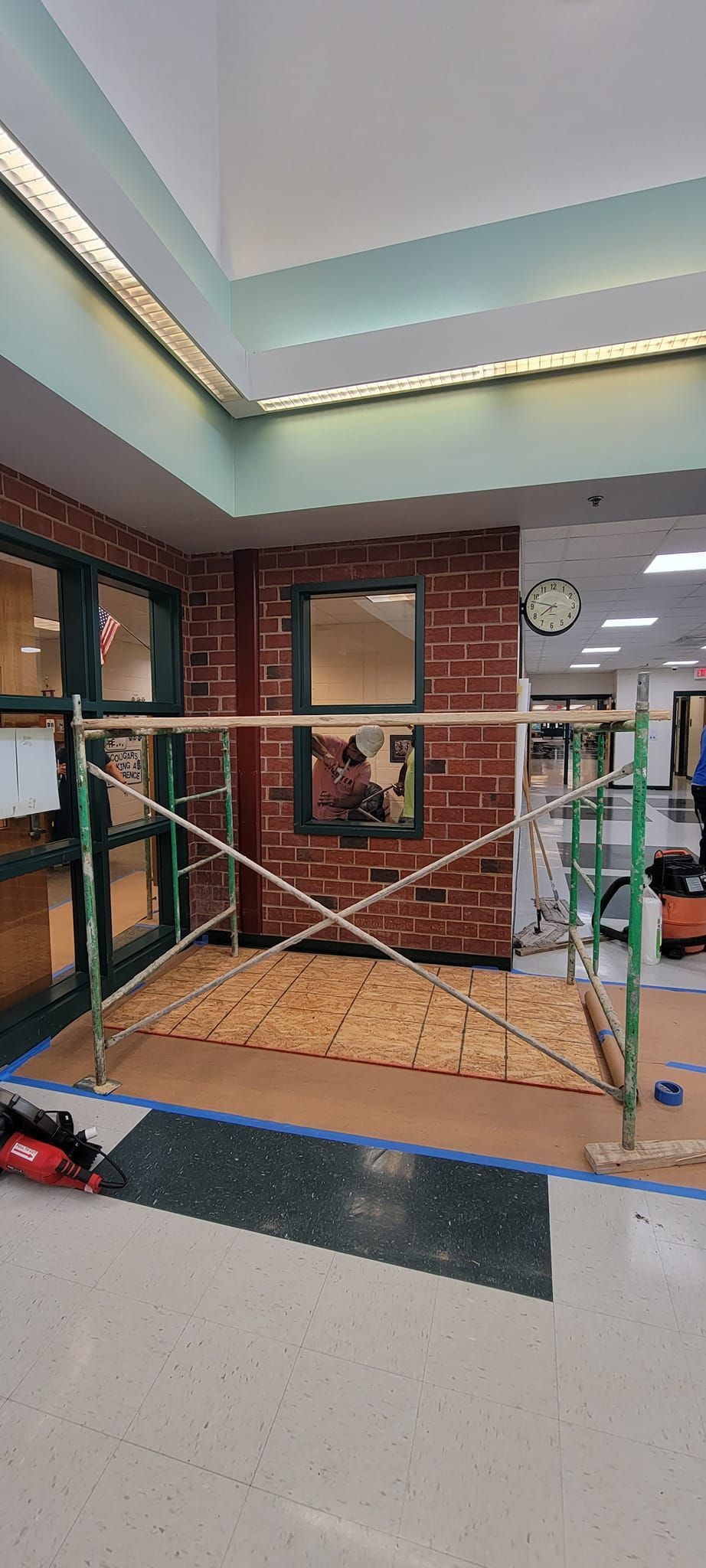 A room with a brick wall and a scaffolding in the middle of it.