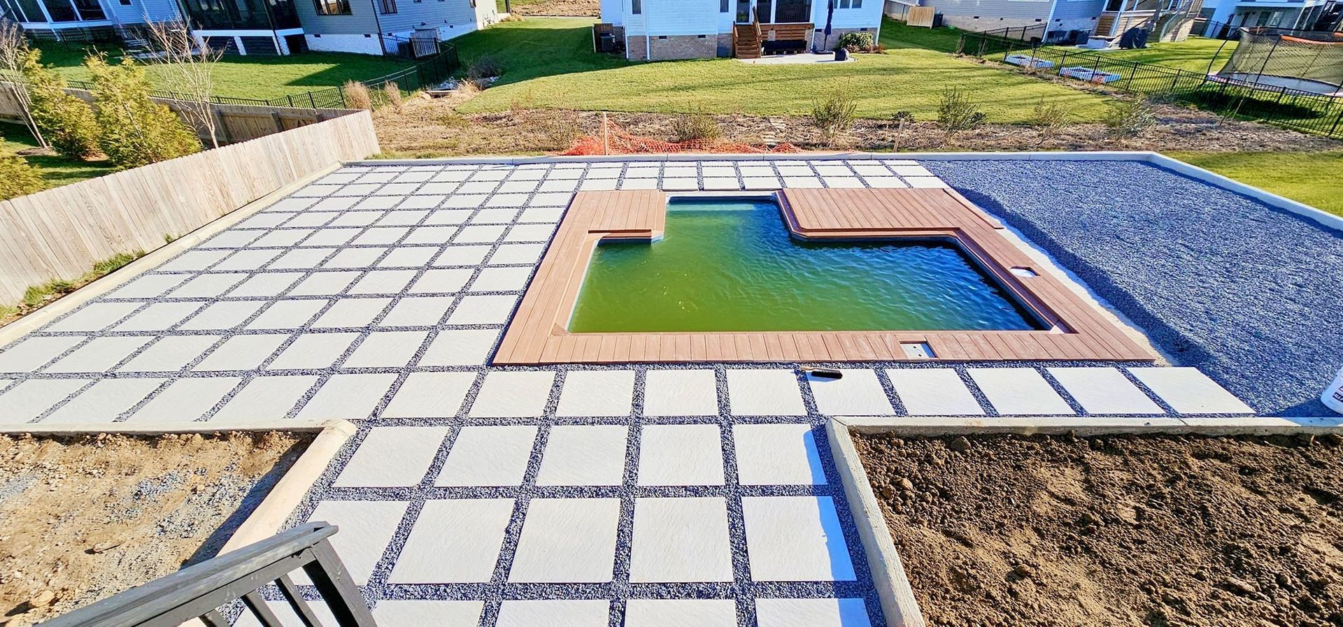 There is a swimming pool in the middle of the backyard.