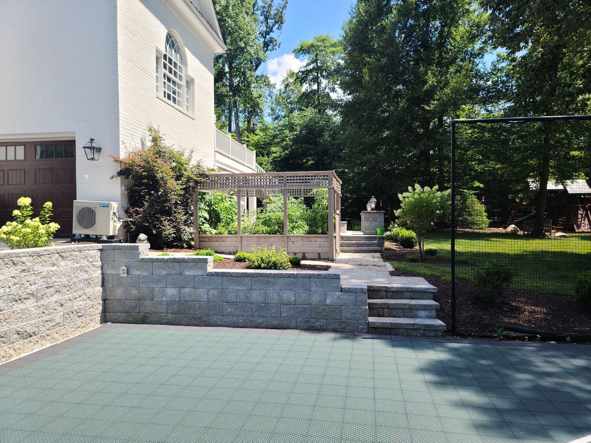 A white house with a basketball court in front of it
