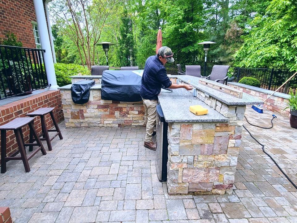 A man is standing at a counter in an outdoor kitchen.