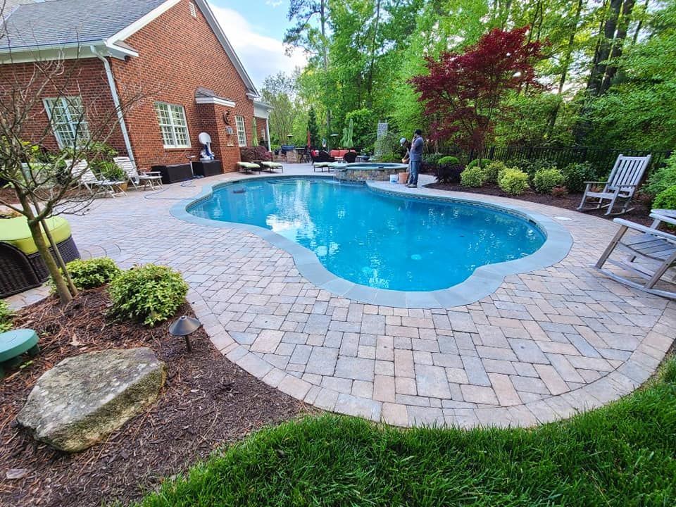 There is a large swimming pool in the backyard of a house.