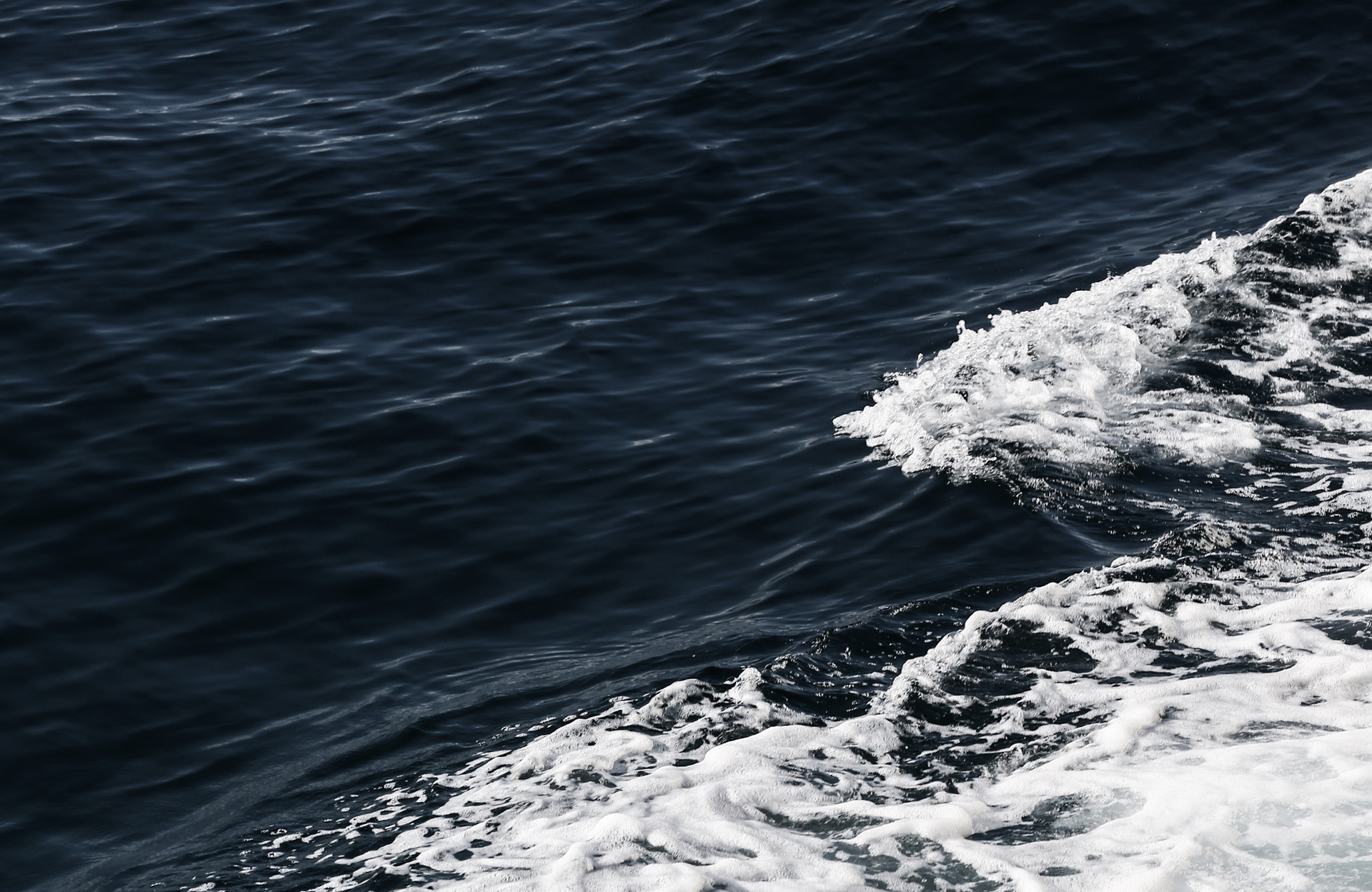 Dark ocean water with white foam waves