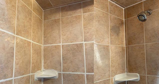 A bathroom with tiled walls and a shower head.