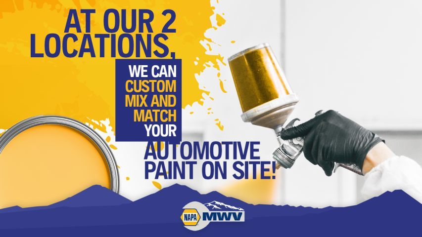 A hand in a black glove holds a paint spray gun against a yellow and blue graphic advertising custom automotive paint mixing.