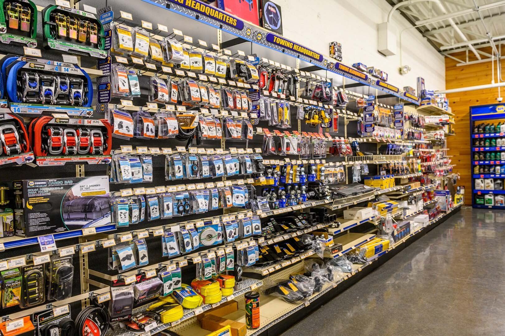 A long retail aisle in an automotive supply store featuring organized shelves filled with various packaged hardware parts.