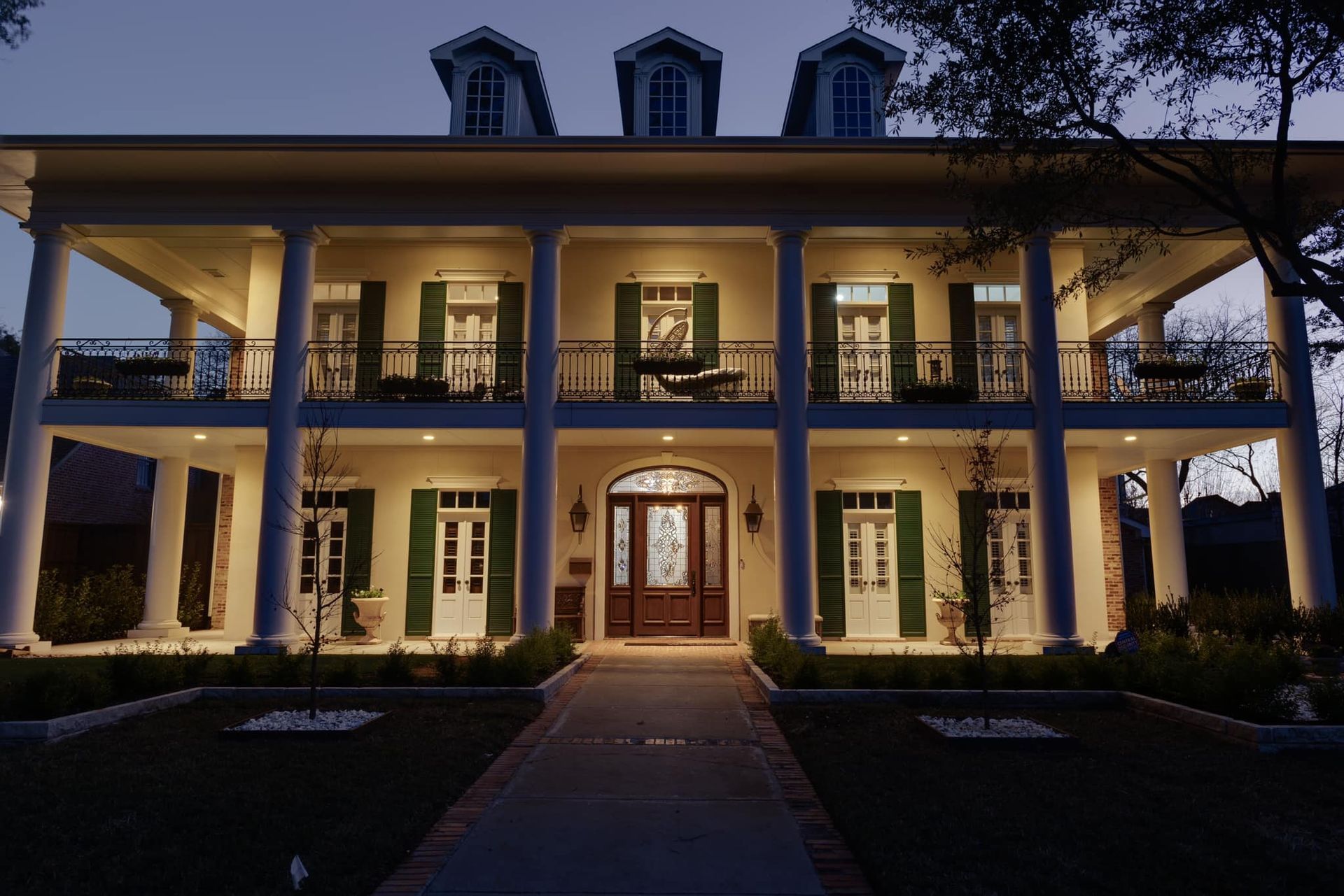 A large house with a lot of windows is lit up at night.    