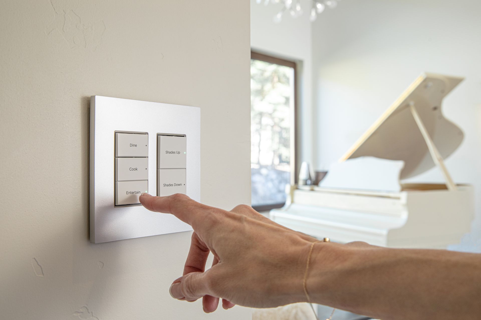 A person is pressing a button on a light switch in a living room. Premier Lighting & Home Automation in Dallas Fort Worth (DFW).
