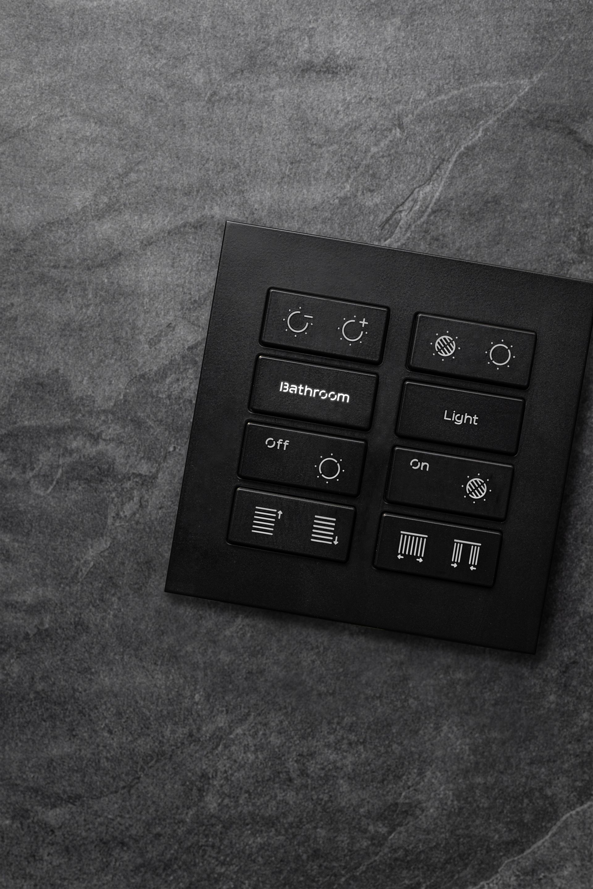 A black and white photo of a remote control on a gray surface.