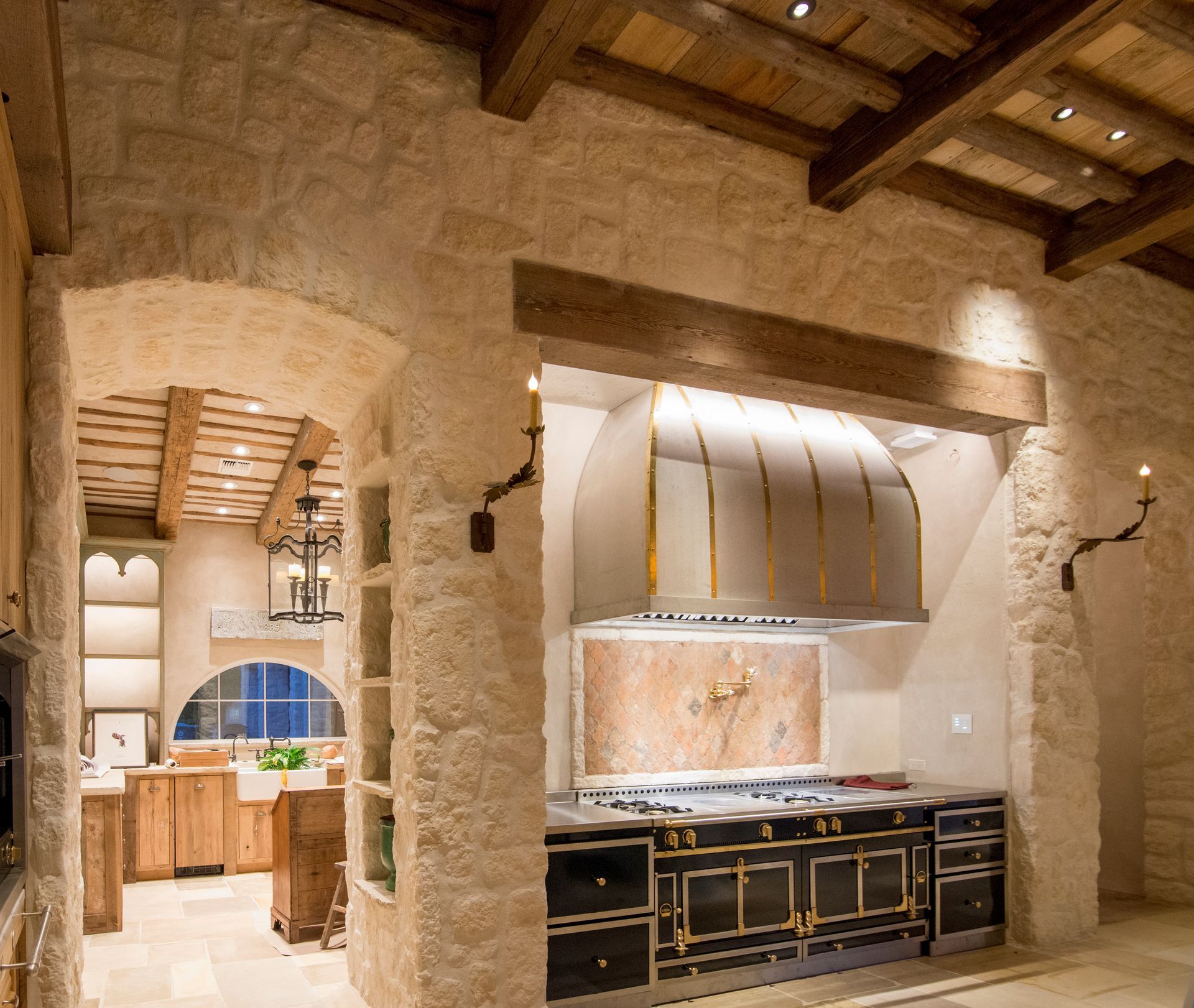 A kitchen with stone walls and wooden beams.    